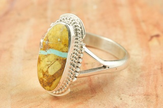 Genuine Boulder Turquoise set in Sterling Silver Ring. The cabachon is Boulder Turquoise, you can see the veins of Turquoise running through the host rock. The Boulder Turquoise Mine is located in northeast Nevada. It was discovered in 1970 by a Shoshone sheep herder. Production is small due to the remote location and winter weather. Boulder Turquoise is valued for both it's beauty and rarity. Every stone is unique. Created by Navajo Artist Larson Lee. Signed by the artist.